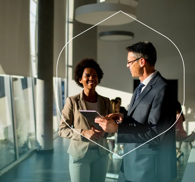 Two coworkers in a bright workplace setting representing employer mental health support.