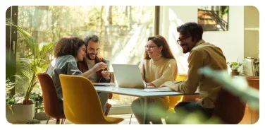 People collaborating around a laptop in a bright workplace.